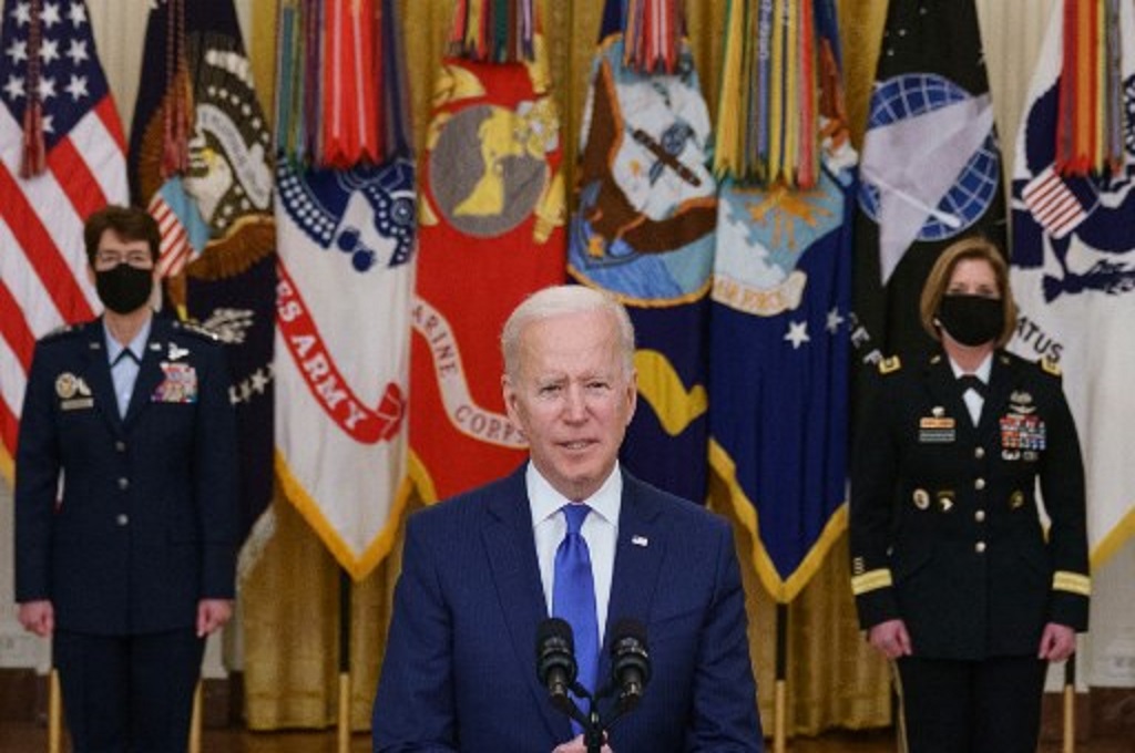 Presiden AS Joe Biden berbicara dengan didampingi Jacqueline Van Ovost (kiri) dan Laura Richardson di Gedung Putih pada Senin, 8 Maret 2021. (MANDEL NGAN / AFP)