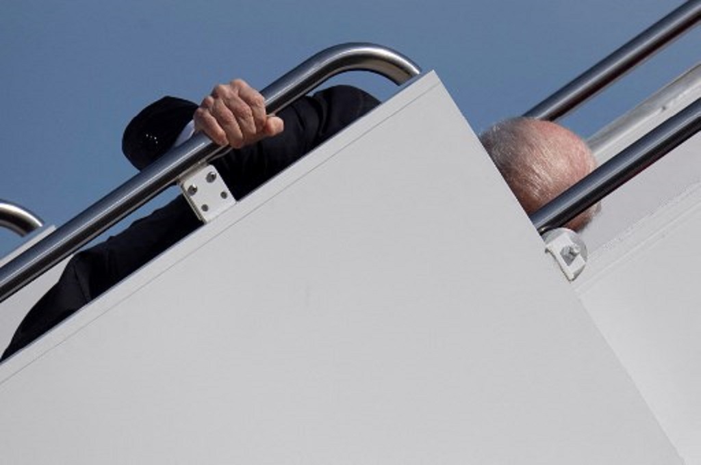 Presiden AS Joe Biden tersandung saat menaiki anak tangga menuju pesawat Air Force One di Maryland pada Jumat, 19 Maret 2021. (Eric BARADAT / AFP)