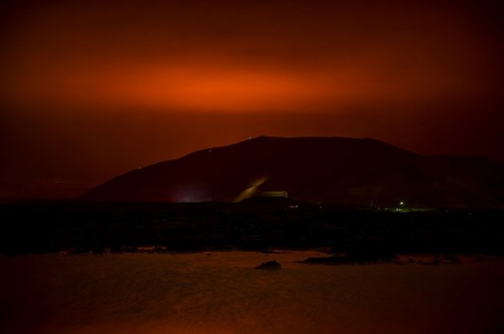 Warna merah dari muntahan lava terlihat dari arah Gunung Fagradalsfjall di Islandia pada Jumat, 19 Maret 2021. (Halldor KOLBEINS / AFP)