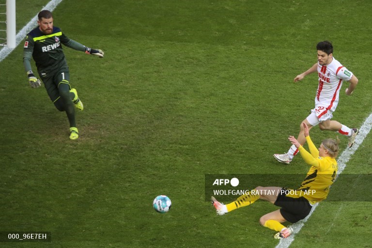Penyerang Borussia Dortmund, Erling Haaland (kiri), menjebol gawang Koeln (AFP/Wolfgang Rattay)