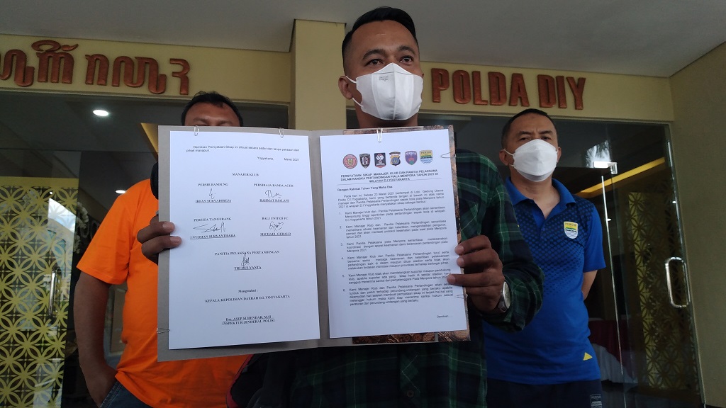Panitia Pertandingan (Panpel) lokal, Tri Mulyanta (depan) menunjukkan kesepakatan berisi untuk menjaga keamanan selama gelaran Piala Menpora 2021, didampingi perwakilan manajer tim. (medcom.id/Ahmad Mustaqim)