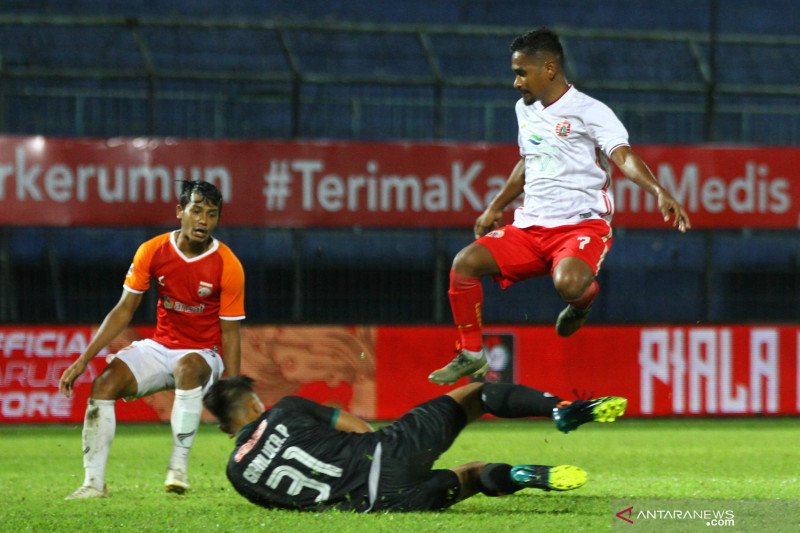 Pesepak bola Persija Jakarta, Ramdani Lestaluhu (kanan) melompati tubuh penjaga gawang Borneo FC Samarinda, Gianluca Claudio Pandeynuwu (bawah). (ANTARA FOTO/Ari Bowo Sucipto)