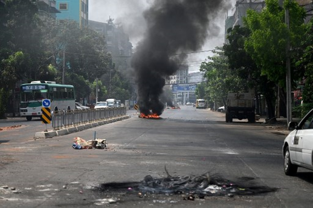 Barikade yang dipasang demonstran anti-kudeta terbakar di salah satu ruas jalan di kota Yangon, Myanmar pada Senin, 29 Maret 2021. (STR / AFP)
