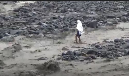 Warga desa terpaksa berjalan kaki sekitar 100 meter di atas banjir lahar Gunung Semeru. (Foto: Metrotv)