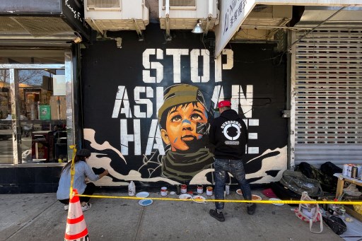 Seniman membuat lukisan mural menentang kekerasan anti-Asia di Amerika Serikat. Foto: AFP