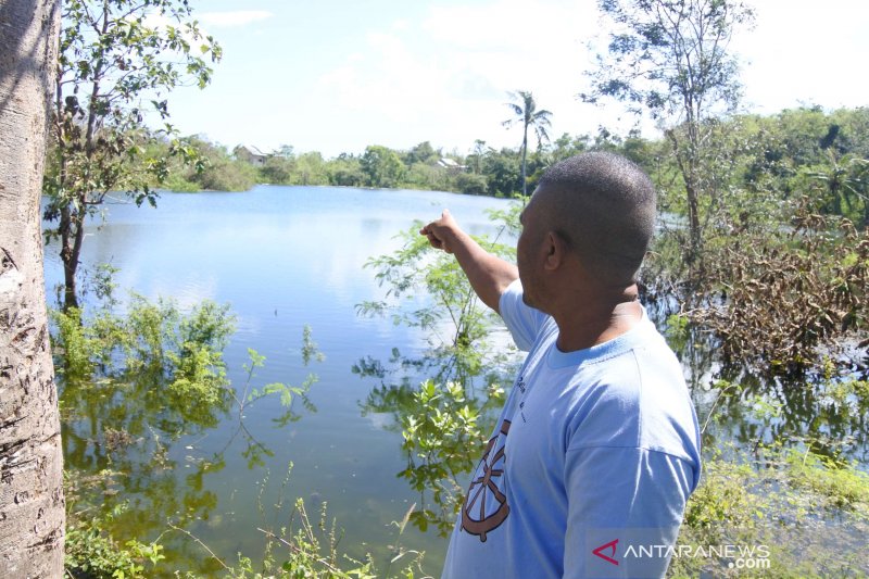  Ambrosius Anone, menunjuk bentangan danau yang baru terbentuk, Minggu, 18 April 2021. FOTO ANTARA/ Benny Jahang