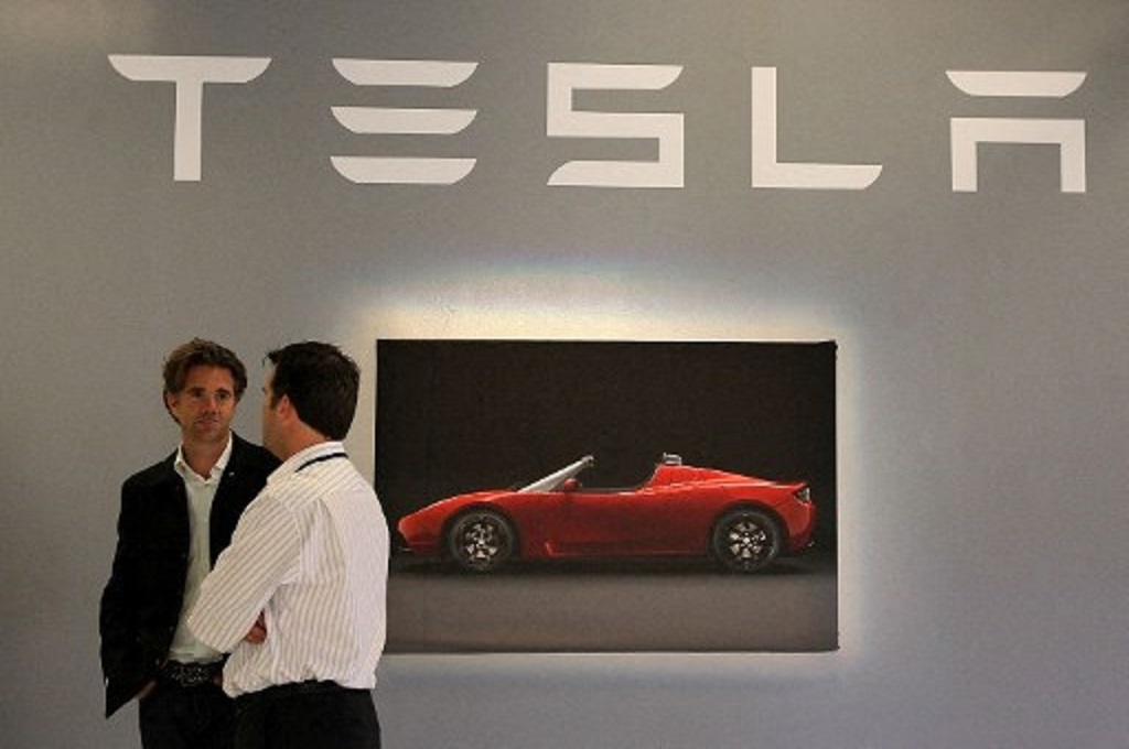 Dua karyawan berbicara menjelang konferensi pers di kantor utama Tesla di California, AS pada 20 Mei 2010. (JUSTIN SULLIVAN / Getty / AFP)