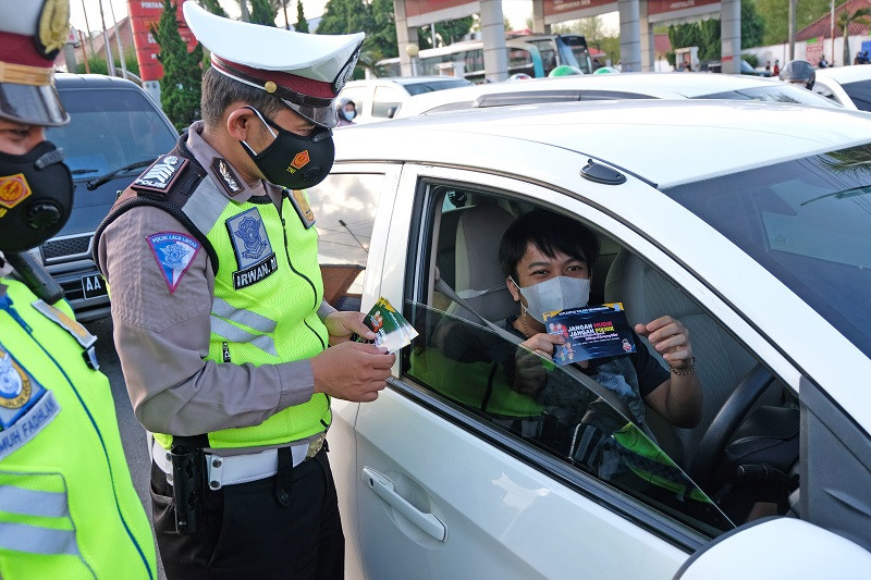 Ilustrasi--Polisi membagikan brosur terkait larangan mudik kepada pengendara di kawasan Terminal Madureso, Temanggung, Jateng. (Foto: ANTARA/Anis Efizudin)