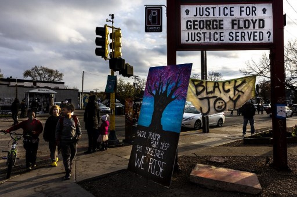 Warga berjalan melintasi George Floyd Square di Minneapolis, AS pada 21 April 2021. (Kerem Yucel / AFP)