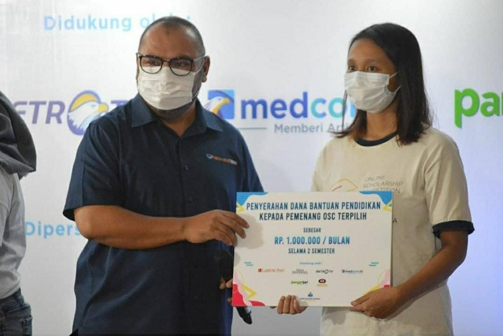 CEO Media Group Mirdal Akib saat menyerahkan bantuan biaya hidup kepada penerima beasiswa OSC. Foto:  Medcom.id
