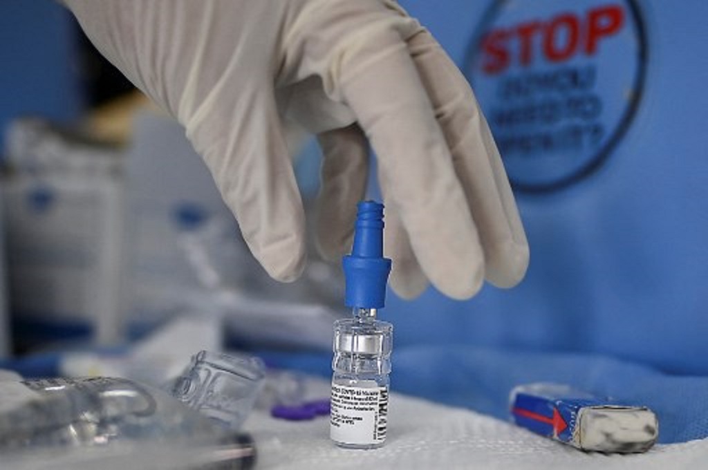 Petugas kesehatan hendak menggunakan vaksin Pfizer dalam program vaksinasi Covid-19. (AFP)