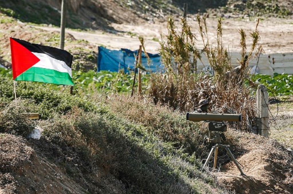 Sebuah bendera Palestina berkibar di dekat lokasi latihan militer Hamas dan beberapa faksi lainnya di kota Gaza pada 29 Desember 2020. (MAHMUD HAMS / AFP)