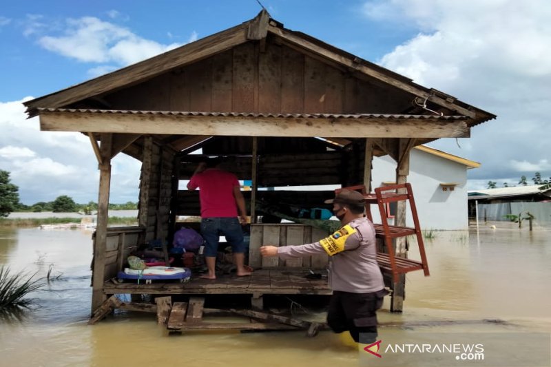 Anggota Polsek Satui, Polres Tanah Bumbu melakukan evakuasi terhadap warga terdampak banjir. (ANTARA/Firman) 