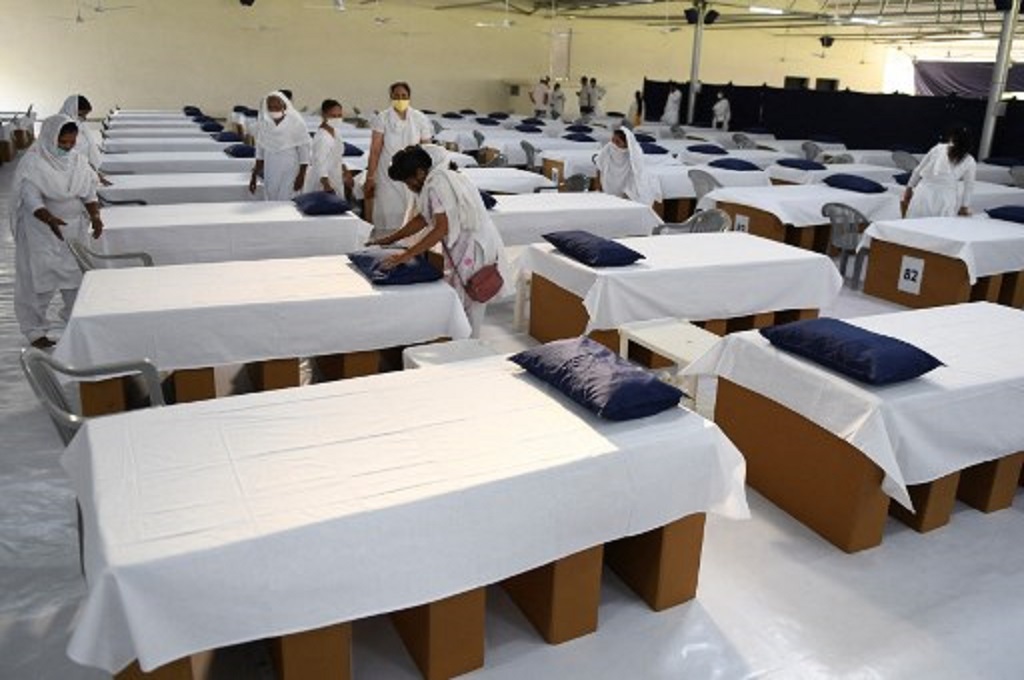 Petugas menyiapkan tempat tidur untuk pasien Covid-19 di sebuah bangunan di Amritsar, India pada 22 Mei 2021. (NARINDER NANU / AFP)