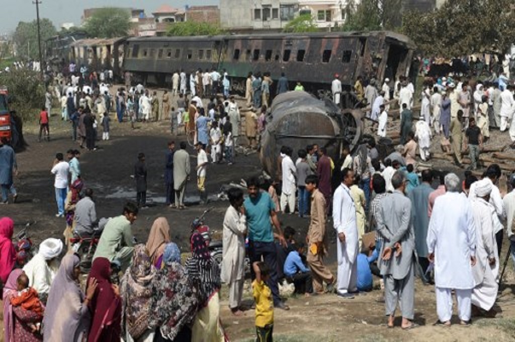 Warga berkumpul di lokasi tabrakan kereta dan bus di Punjab, Pakistan pada 28 Maret 2017. (ARIF ALI / AFP)