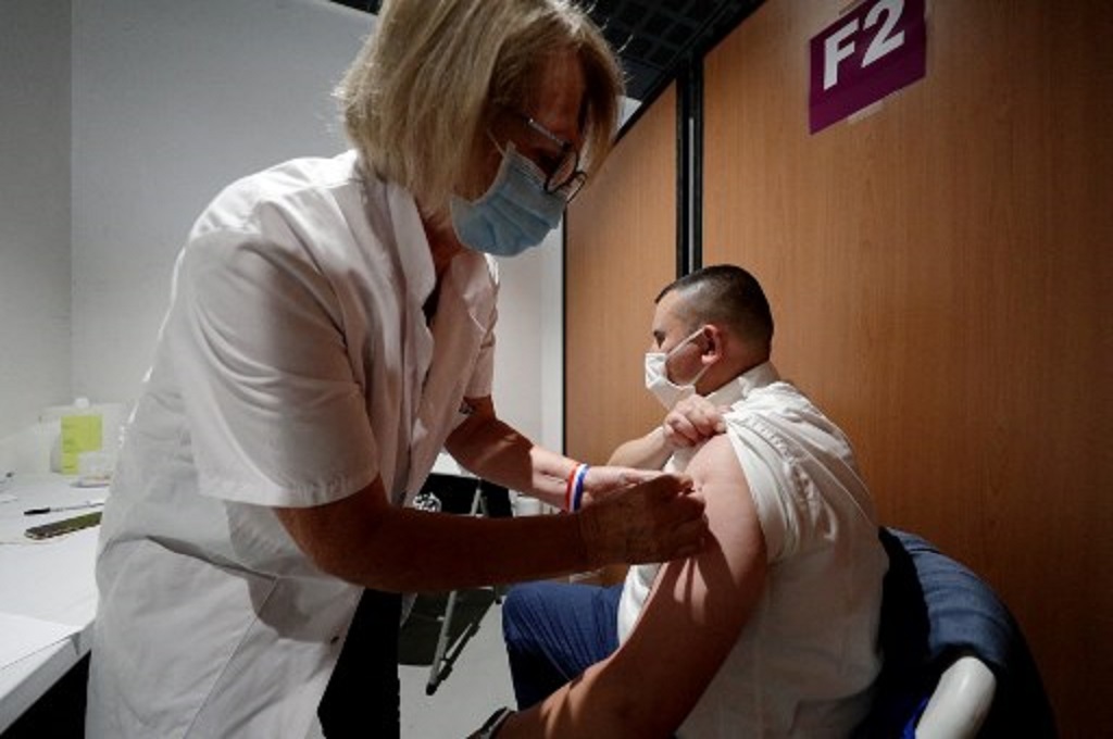 Tenaga kesehatan menyuntikkan vaksin Covid-19 ke seorang warga di Poissy, Prancis, 23 Juni 2021. (GEOFFROY VAN DER HASSELT / AFP)