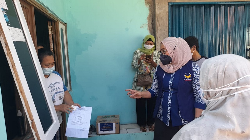   Ketua DPD Partai NasDem Kota Cirebon, Eti Herawati saat membagikan sembako bagi warga yang sedang Isoman. 