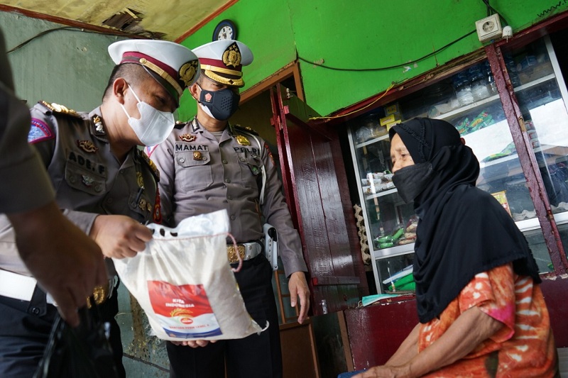  Jajaran Ditlantas Polda Sulsel, saat membagikan sembako kepada pedagang kaki lima di Kota Makassar, Sulawesi Selatan, Kamis, 29 Juli 2021. 