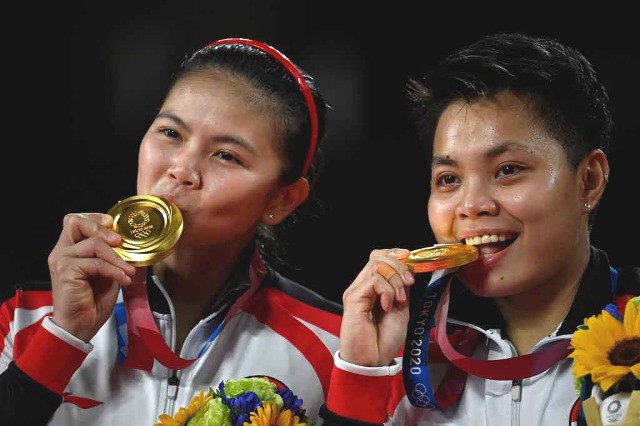 Mengapa setelah menang para atlet suka menggigit medali emasnya? Ini jawabannya. (AFP PHOTO/Alexander Nemenov)