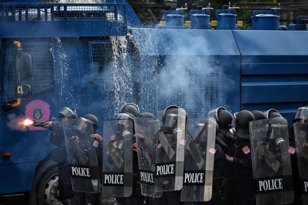 Polisi berusaha memukul mundul demonstran yang menuntut reformasi politik dan menyerukan perubahan pada program vaksinasi virus korona di Thailand. AFP/Lillian Suwanrumpha