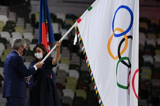 Presiden IOC Thomas Bach menyerahkan bendera Olimpiade kepada Wali Kota Paris Anne Hidalgo. (Daniel LEAL-OLIVAS / AFP)