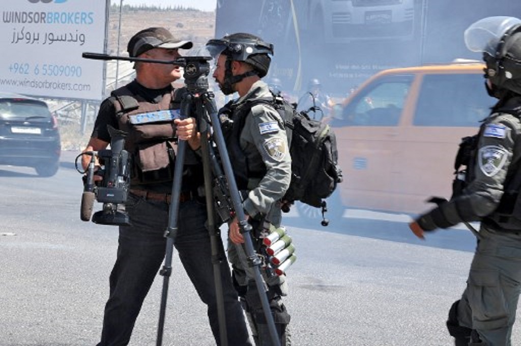 Pasukan Israel berhadapan dengan seorang reporter dalam bentrokan dekat Ramallah, Tepi Barat, 17 Agustus 2021.  (ABBAS MOMANI / AFP)