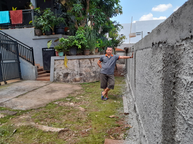 Pujiono berdiri di samping pagar yang menutup akses jalan rumahnya di Kampung Bulak, Kelurahan Serua, Ciputat, Tangerang Selatan, Kamis, 9 September 2021. Medcom.id/ Farhan Dwitama
