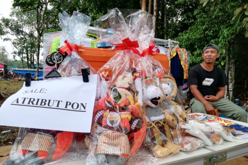 Penjual atribut Pekan Olahraga Nasional (PON) XX Papua menjajakan dagangannya di sekitar Mimika Sport Centre, Mimika, Kamis (30/9/2021). (ANTARA/Zuhdiar Laeis)