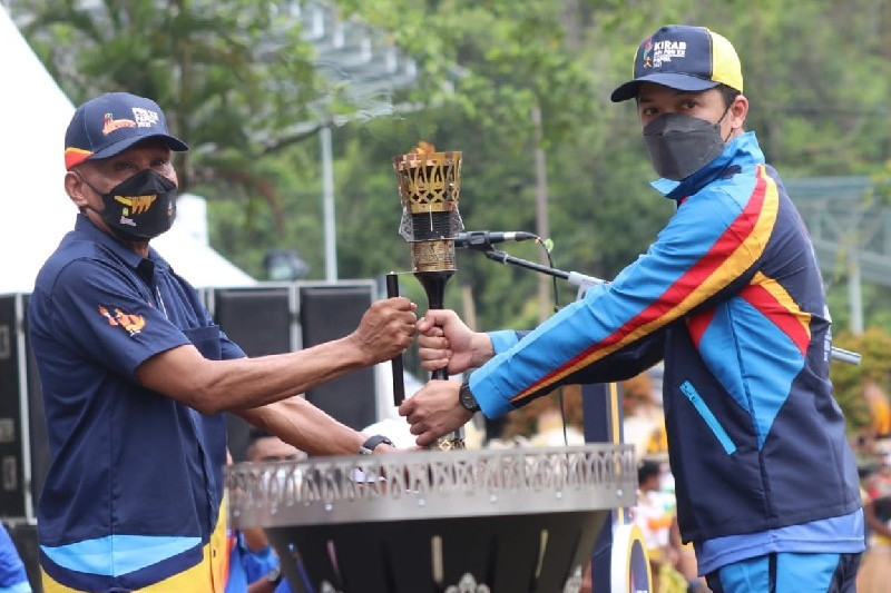 Taufik Hidayat (kanan) menyerahkan obor api PON XX ke Wali Kota Jayapura Benhur Tomi Mano (ANTARA/HO/Humas Pemkot Jayapura)