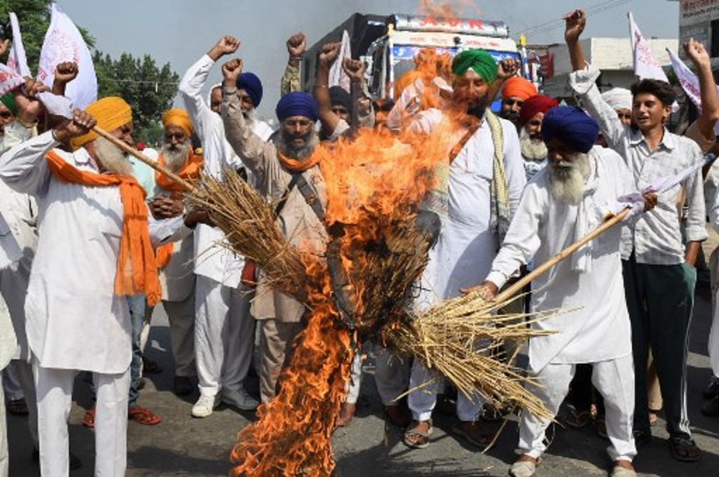 Sekelompok petani membakar boneka jerami dalam unjuk rasa di Amritsar, India, 6 Oktober 2021. (NARINDER NANU / AFP)