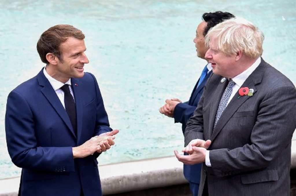 Presiden Prancis Emmanuel Macron (kiri) berbicara dengan PM Inggris Boris Johnson di sela-sela KTT G20 di Roma, Italia, 31 Oktober 2021. (Andreas SOLARO / AFP)