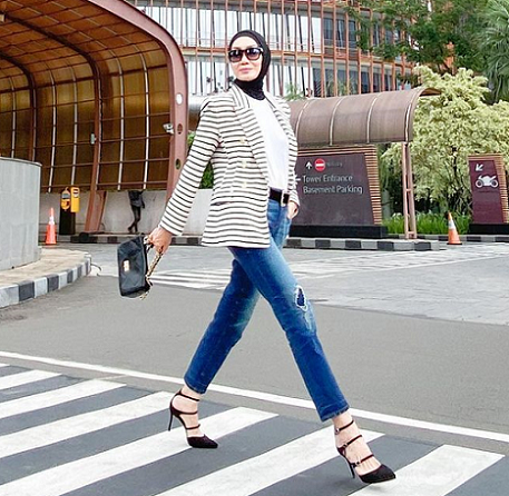 Untuk tampilan kasual namun tetap terlihat formal, Okky memadukan blazer garis-garis dengan celana jeans dan heels. (Foto: Dok. Instagram/@okkyasokawatireal)