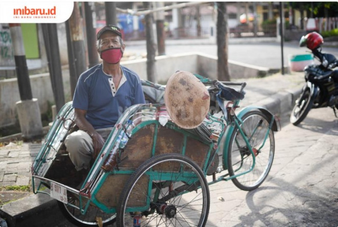 Seorang tukang becak beristirahat di tepi jalan setelah seharian belum mendapat penumpang. (Inibaru.id/ Bayu N)