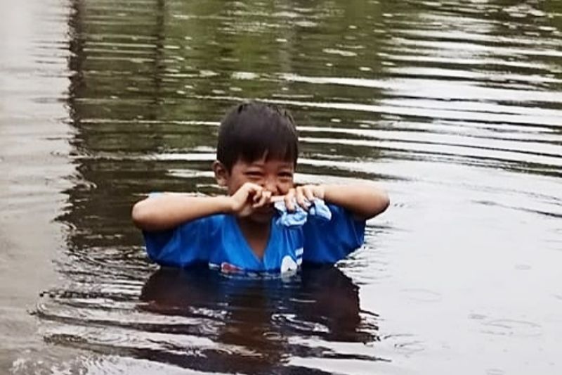 Seorang anak berada di sebuah jalan desa yang kini terendam banjir cukup dalam di Kecamatan Cempaga Hulu, Kabupaten Kotim, Kalteng, Sabtu (13/11/2021). (FOTO ANTARA/HO-BPBD Kotim)
