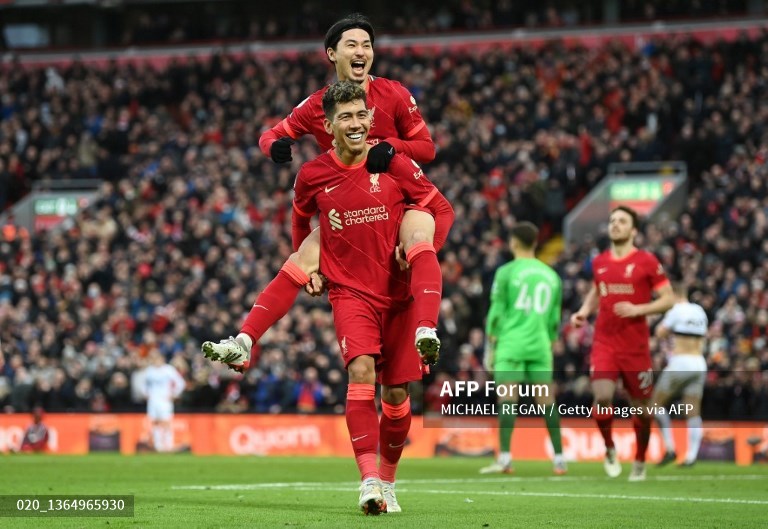 Penyerang Liverpool, Takumi Minamino, merayakan golnya ke gawang Brentford bersama Roberto Firmino (AFP/Michael Regan)