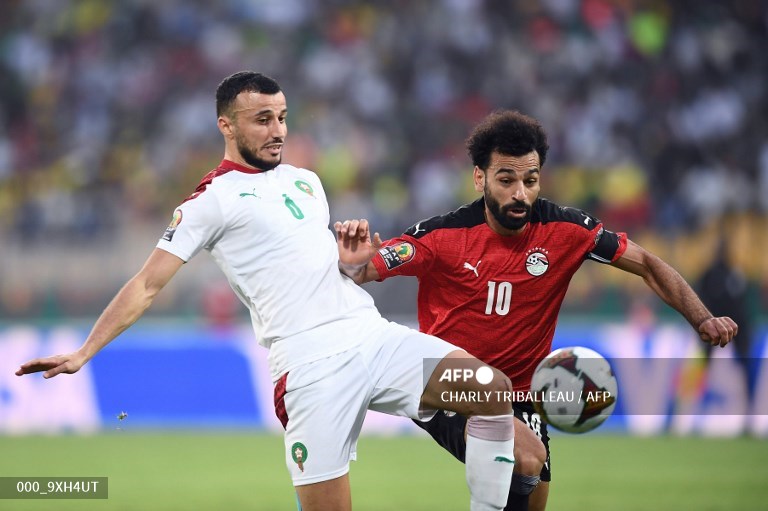 Penyerang Mesir, Mohamed Salah (kanan), berduel dengan bek Maroko, Romain Saiss (AFP/Charly Triballeau)