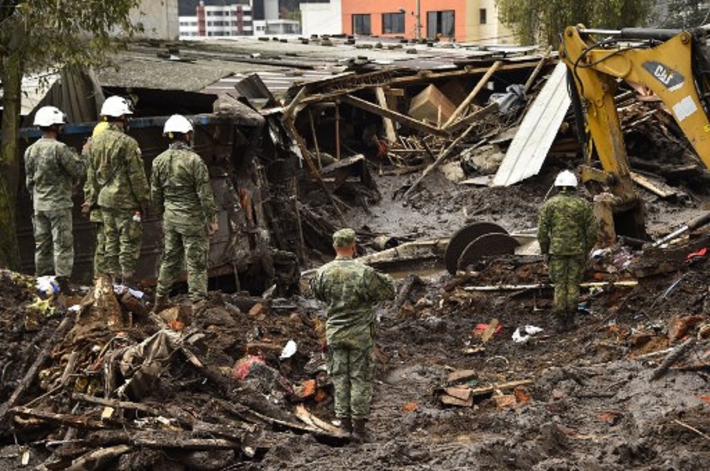 Petugas berada di lokasi longsor di La Gasca, Quito, Ekuador, 1 Februari 2022. (Rodrigo BUENDIA / AFP)