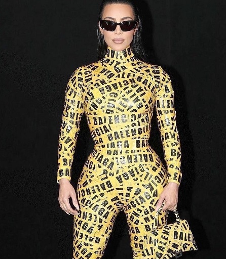 Kim mengenakan kostum pita kuning bertuliskan Balenciaga lengkap dengan tas yang juga dibalut pita kuning. (Foto: Dok. Instagram/@festivalmodedesign)