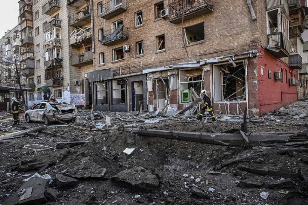 Seorang petugas pemadam kebakaran berjalan di area yang terkena serangan artileri Rusia di Kiev, Ukraina, 14 Maret 2022. (AFP)
