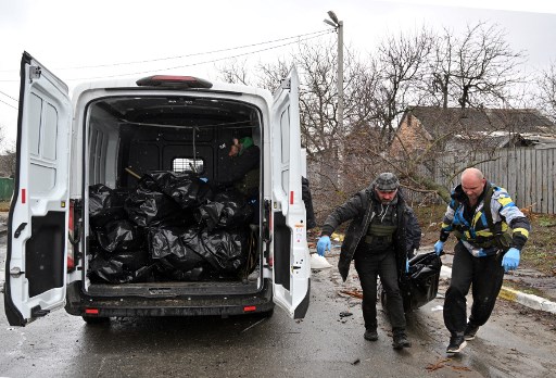 Pekerja membawa mayat warga sipil yang tewas di Buscha, Ukraina. Foto: AFP