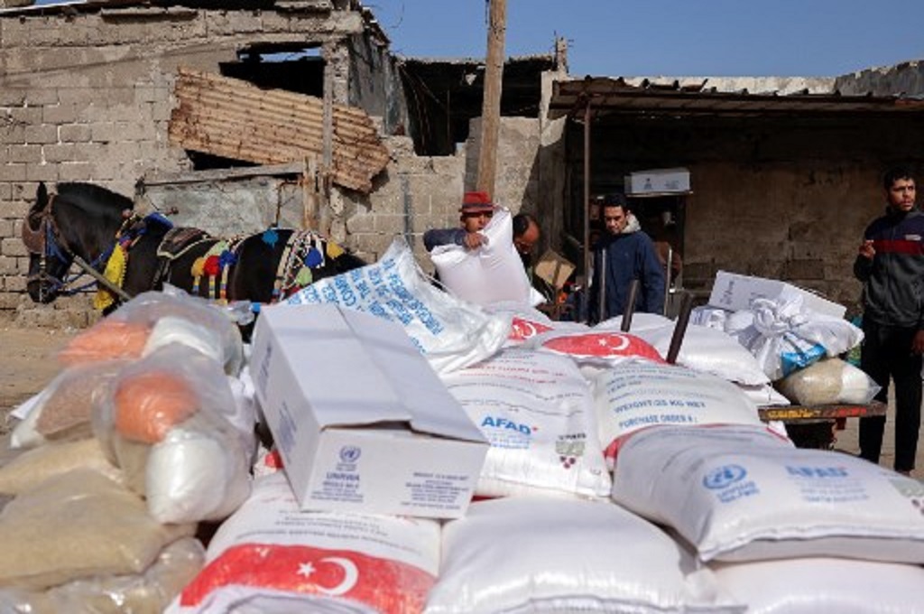 Warga Palestina mengambil bantuan makanan di pusat distribusi UNRWA di Gaza, 1 Maret 2022. (MOHAMMED ABED / AFP)