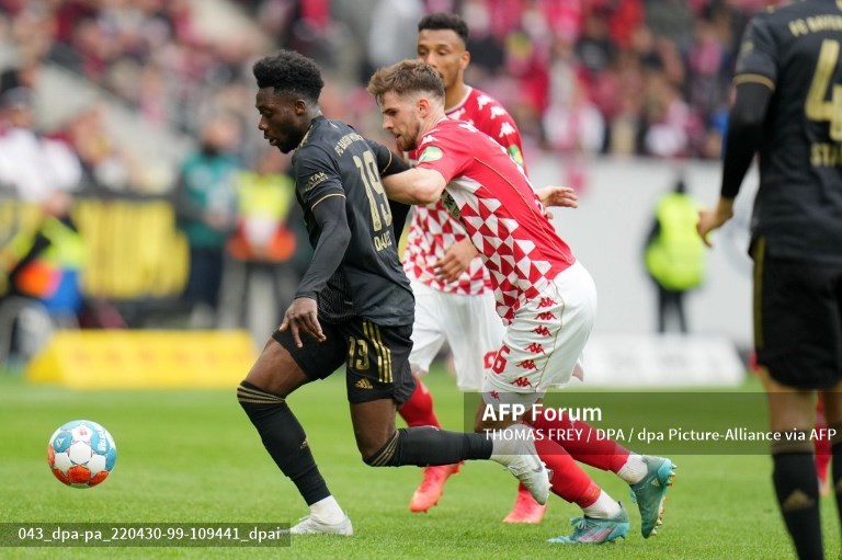 Bek Bayern Muenchen, Alphonso Davies, berusaha melewati gelandang Mainz, Anton Stach (AFP/Thomas Frey)
