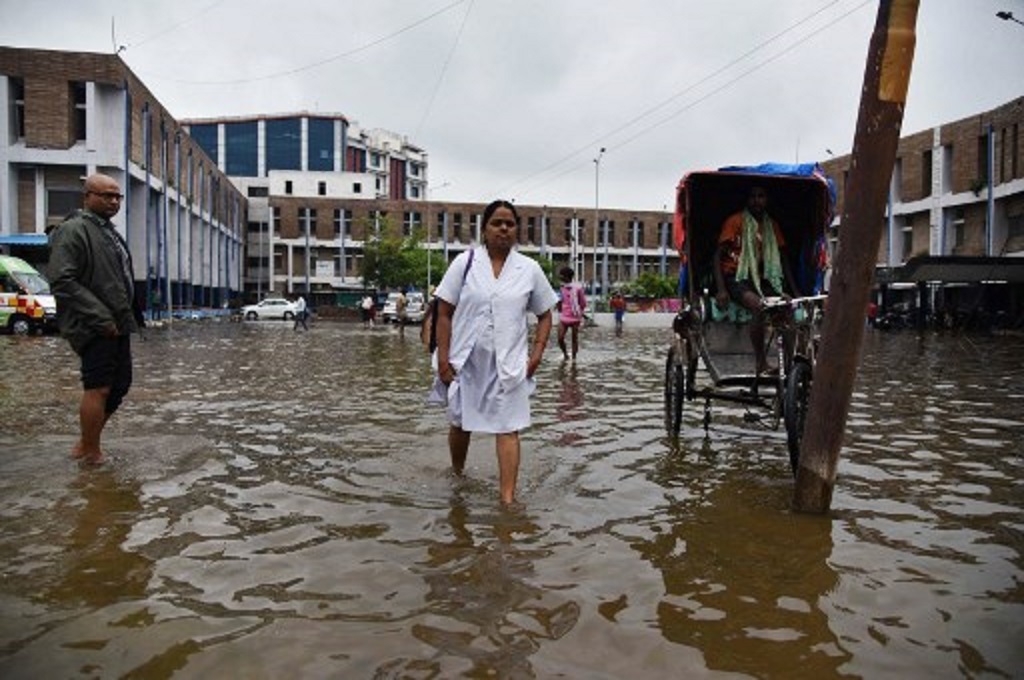 Warga berjalan di tengah banjir di Patna, Bihar, India, 30 September 2019. (Sachin KUMAR / AFP)