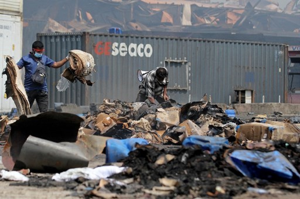 Petugas memeriksa lokasi kebakaran di sebuah depot kontainer di Sitakunda, Bangladesh, 5 Juni 2022. (AFP)