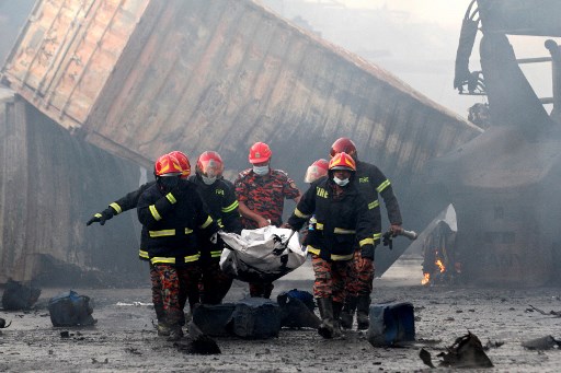 Petugas penyelamat mengeluarkan jenazah dari lokasi kebakaran depot kontainer Bangladesh./AFP