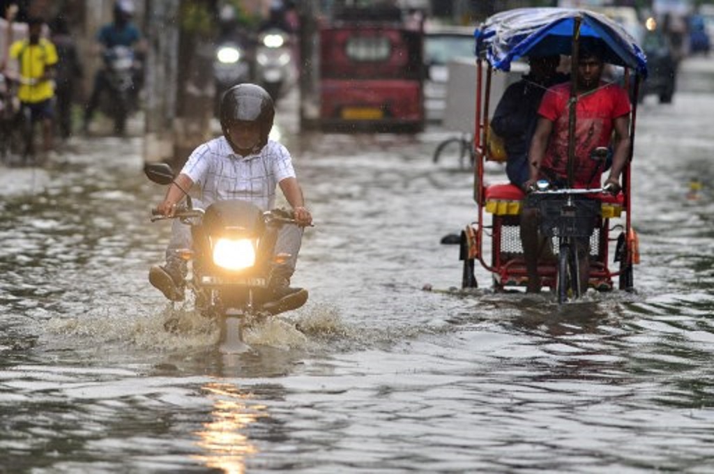 Warga beraktivitas di tengah banjir di kota Guwahati, Assam, India, 25 Mei 2022. (Biju BORO / AFP)