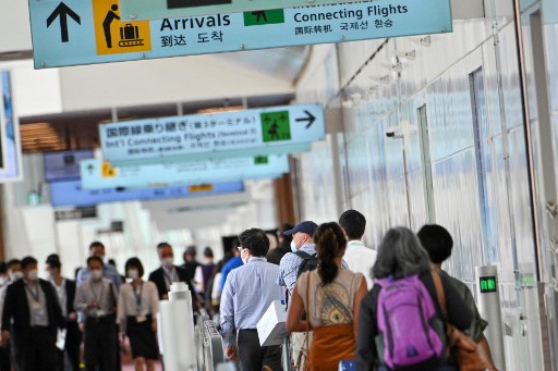 Pendatang di Bandara Internasional Haneda, Jepang menuju tempat karantina covid-19. Foto: AFP