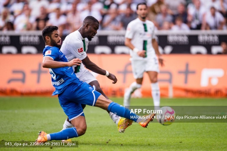 Penyerang Gladbach, Marcus Thuram, mencoba menembak meski dikawal bek Hoffenheim, Ozan Kabak (AFP/Marius Becker)
