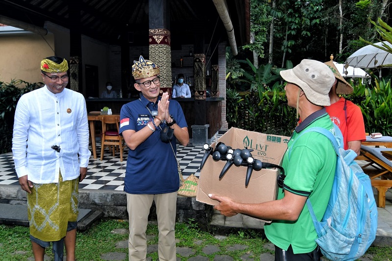 Menparekraf Sandiaga (baju biru) memberikan trekking pole untuk pemandu wisata di Bangli. (istimewa)
