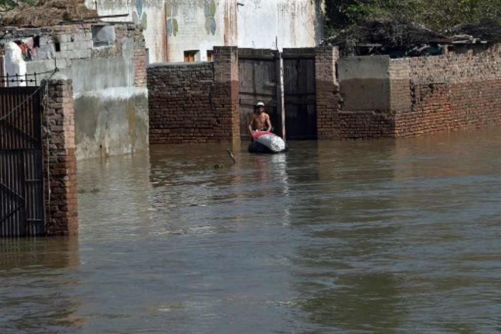 Seorang warga berada di tengah banjir di distrik Charsadda, Khyber Pakhtunkhwa, Pakistan, 29 Agustus 2022. (Abdul MAJEED / AFP)